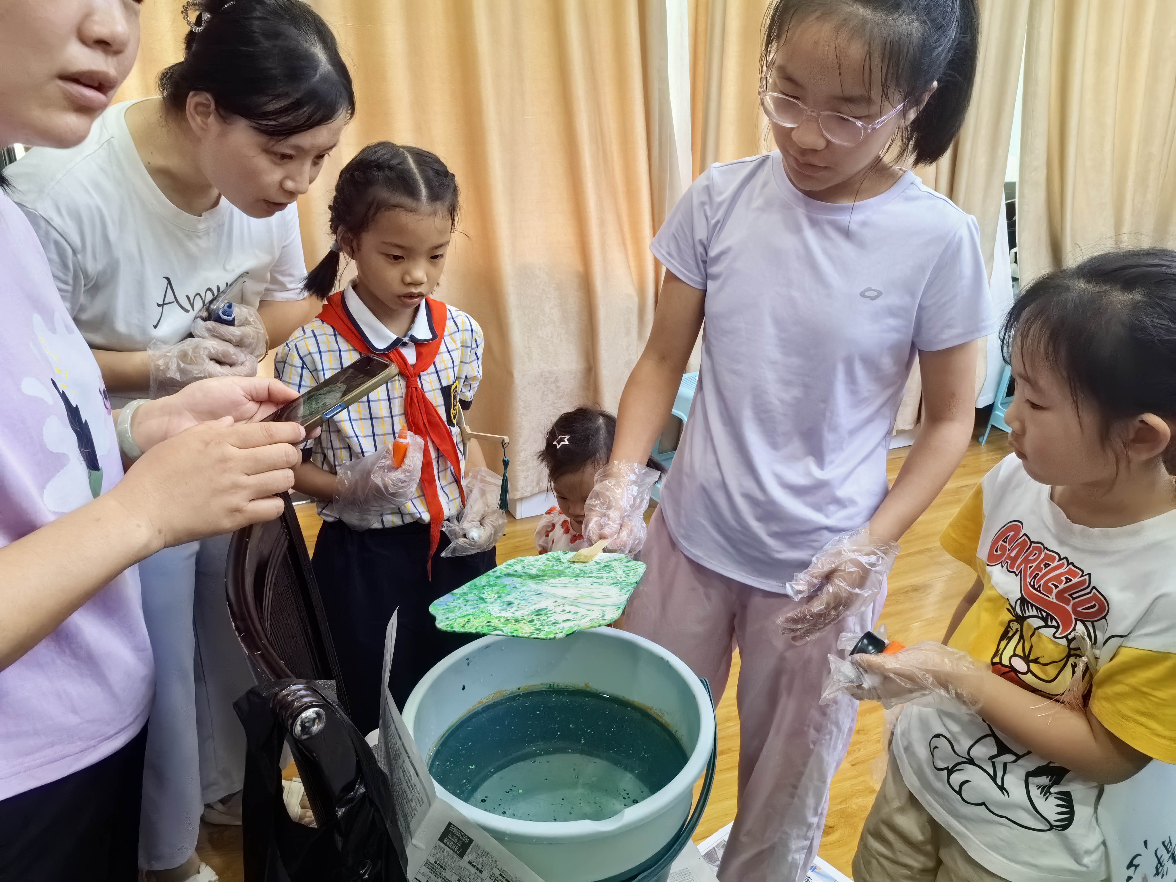 1723281960972544.jpg 讲解员与志愿者引导大家做漆扇2.jpg