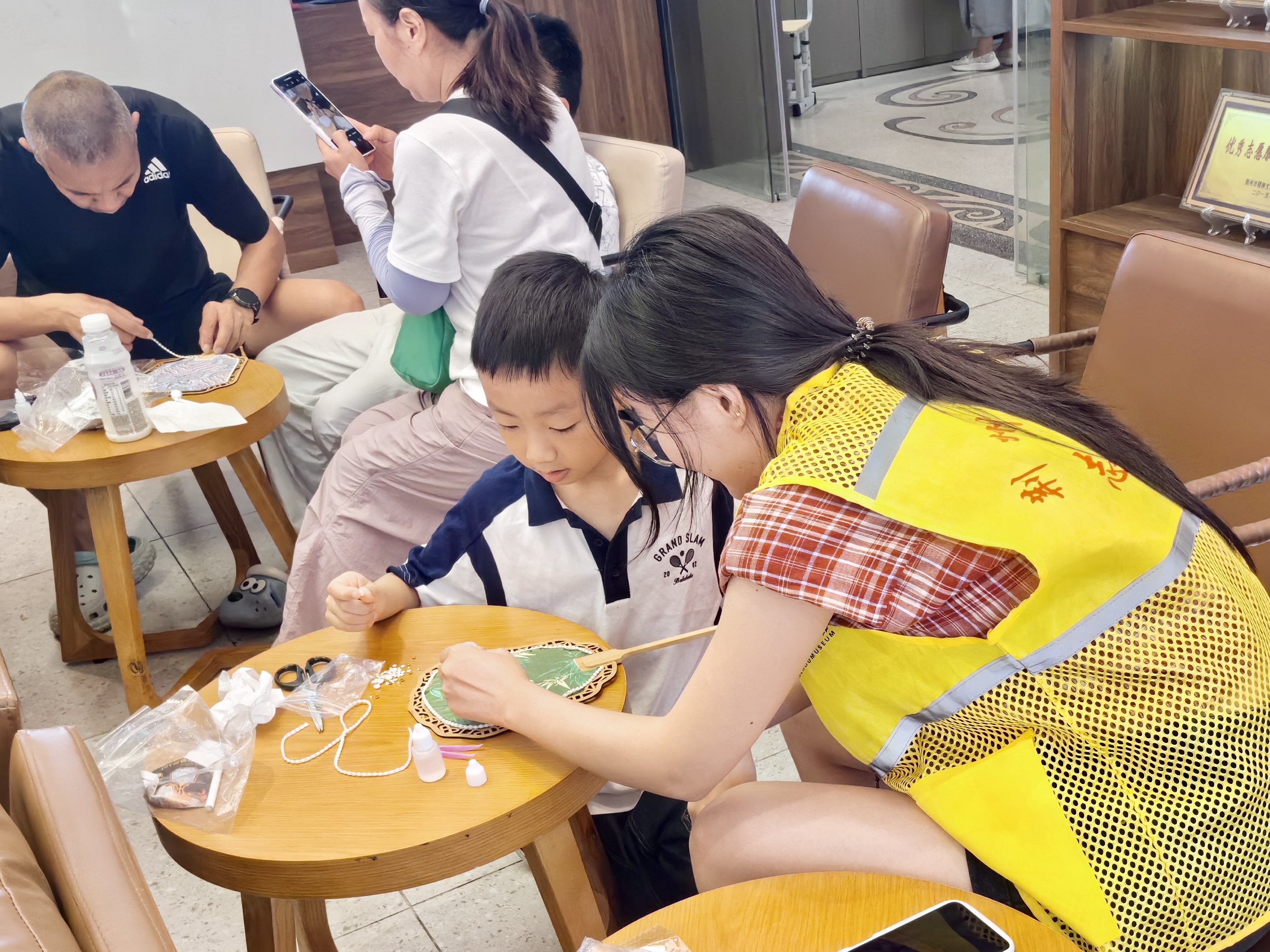 3.志愿者帮助游客完成团扇.jpg